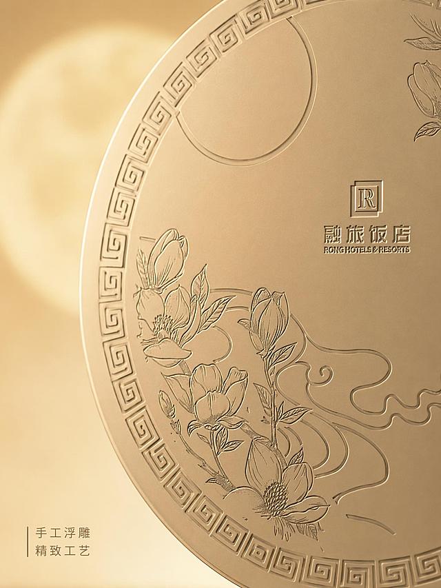 [主图-3] 礼盒细节雕刻纹理特写图。氛围风格：高级质感，精致细节呈现，商业摄影微距特写。元素：特写原圆形礼盒盒面的玉兰花雕刻纹饰和“融旅饭店”文字区域，保持产品纹理、颜色、所有文字完全不变，不修改任何文字，盒面必须保留融旅饭店字样。放大展示雕刻的细腻线条和金属哑光质感。背景为朦胧的中秋圆月浅金色渐变背景，无人手无人物。光影：侧光突出雕刻纹理立体感，明暗对比清晰，细节锐利。配色：香槟金为主，背景浅金渐变，简洁高级。视角构图：局部特写，雕刻区域占画面70%，对焦清晰。文字版式：左下角小字标注“手工浮雕 精致工艺”，浅棕色细体，不遮挡核心细节。输出要求：3:4 比例，文字清晰，超高清微距商业摄影质感。负向提示词：变形，文字模糊，改变原雕刻文字，人手人物，杂乱背景。