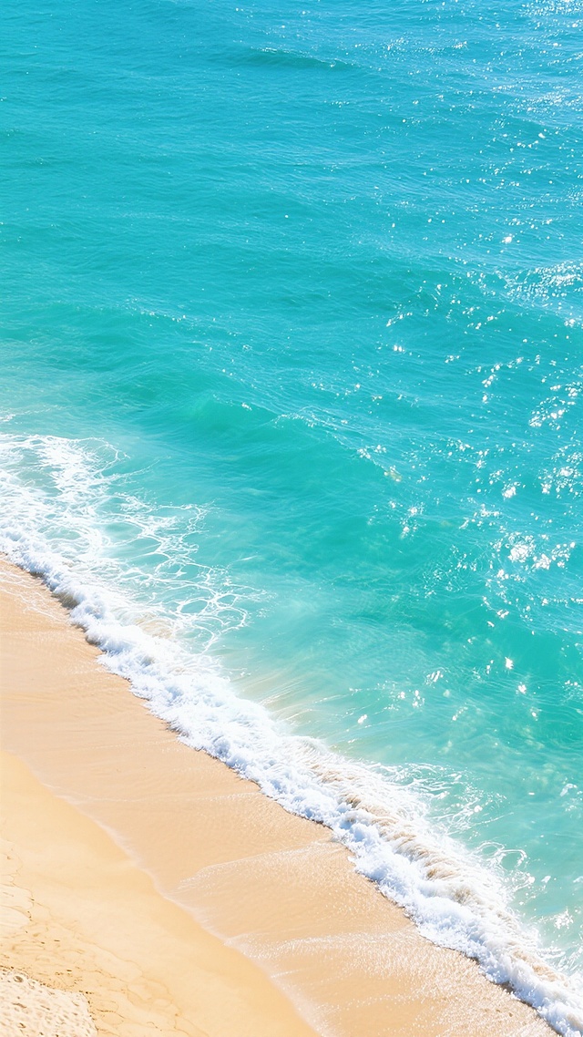 一张航拍视角的海滩风景照片，画面下方是细腻柔软的金黄色沙滩，海浪正轻柔地拍打着 shoreline，形成一道白色的浪花边缘。海水呈现出从岸边透明的浅蓝色逐渐过渡到远处深邃的蓝绿色调，阳光照射下波光粼粼，海面上有一些自然的白色浪花纹理，整体风格清新明亮，色彩饱和度高，光影对比柔和，营造出宁静而治愈的夏日海边氛围。