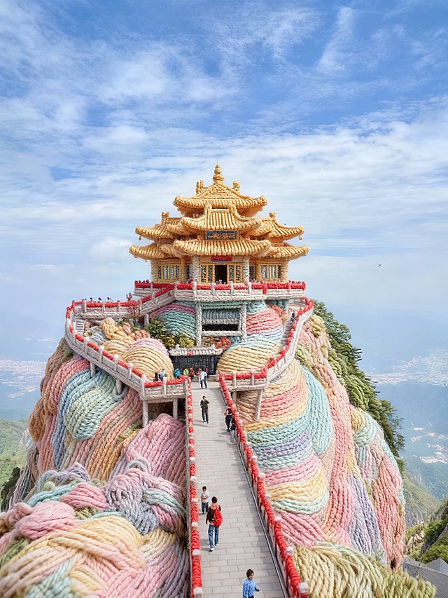 建筑整体呈现出全毛线质感的风格，毛线有层次感，毛线颜色为马卡龙色调。建筑保留原始形状，各个部分都如同被柔软的毛绒材质精心包裹